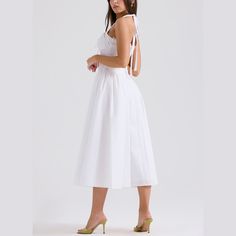 Embrace timeless beauty with this stunning A-line fit and flare midi dress. The halter neck provides a classic yet contemporary look, ideal for any fashionable wardrobe. Delicately crafted with pleated sides on the skirt, this dress combines elegance with a playful twist. Whether you’re attending a garden party, a cocktail event, or a dinner date, this dress is your go-to for effortless style and grace. Color: White, Pink, FloralSilhouette: Fit & FlareLength: MidiMaterial: PolyesterNeckline: Hal Spring A-line Midi Dress With Tie Straps, Spring Backless A-line Sundress, Spring A-line Backless Sundress, Chic A-line Tea Length Summer Dress, A-line Sundress With Tie Straps, Elegant Solid A-line Sundress, Chic A-line Dress With Smocked Back, Elegant A-line Sundress With Tie Back, Chic A-line Maxi Dress With Tie Back