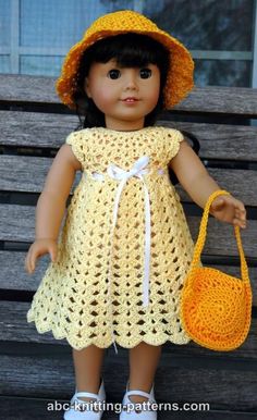 a doll wearing a yellow crochet dress and hat holding a purse on a bench