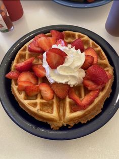 a waffle topped with whipped cream and strawberries