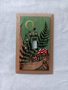 a wooden light switch cover with an image of a mushroom on the tree and leaves