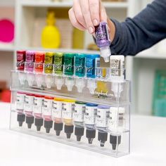 a person is holding an assortment of different colored inks