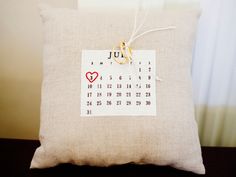 a pillow with a calendar on it and a pair of scissors hanging from the front