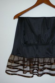 "An exquisite accessory for your wardrobe, this underskirt slip worn with your skirt or dress will make you feel very special ! It is made of black nylon with elastic waistband and three-tiered brown chocolate tulle ruffle 6\" long trimmed with 2 yards of satin ribbon. Standard length is 25\" and petite is 21\". This accessory makes a perfect gift! Hand wash in cold water. Available in color: 1-Brown 2-Black, 3-White, 4-Cream 5-Orange 6-Turquoise 7-Purple 8-Royal Blue 9-Navy 10-Bright Pink 11-Ye Elegant Sheer Tiered Skirt, Elegant Tiered Skirt Petticoat For Party, Elegant Tiered Petticoat For Party, Elegant Tiered Skirt Party Petticoat, Elegant Tiered Party Petticoat, Elegant Ruffled Petticoat For Party, Elegant Long Skirt Petticoat For Party, Elegant Long Party Petticoat, Elegant Tiered Skirt With Attached Cancan