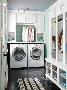 a washer and dryer in a laundry room with white cabinets, black tile floor