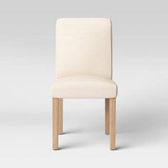 a white upholstered chair with wooden legs and backrests, viewed from the front