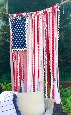 an american flag hanging from a tree with red, white and blue ribbons on it