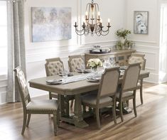 a dining room table with chairs and a chandelier