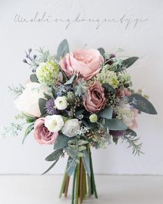 a bouquet of flowers sitting on top of a white table next to a sign that says, wedding bouquets