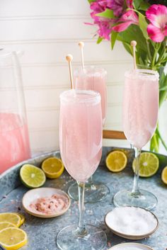 there are two glasses with lemons on the table