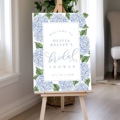 a blue hydrangea bridal shower sign sitting on top of a easel