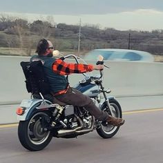 a man riding on the back of a motorcycle down a highway