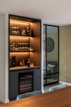 a room that has some shelves with bottles and glasses on it in front of a window