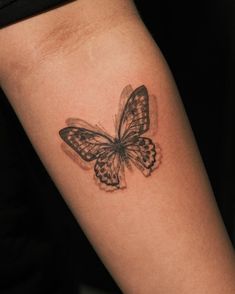 a small butterfly tattoo on the right arm and leg, it appears to be black and white