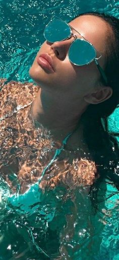 a woman wearing sunglasses floating in the water