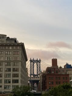 an airplane flying in the sky over some buildings and a bridge with a clock on it