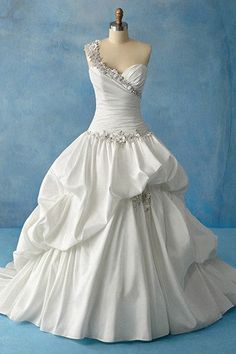 a white wedding dress on a mannequin headdress in front of a blue background