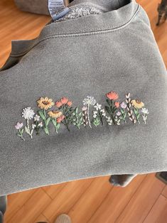 embroidered flowers on the back of a gray sweatshirt