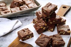 chocolate fudge brownies stacked on top of each other in front of a baking pan