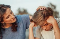 two women who are sitting down and one is holding her head in her hands while the other holds her hair