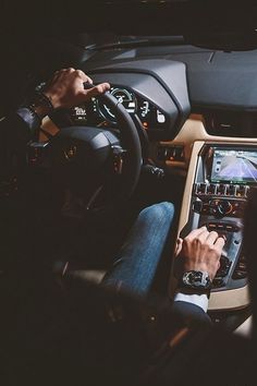 a man sitting in the driver's seat of a car with his hands on the steering wheel