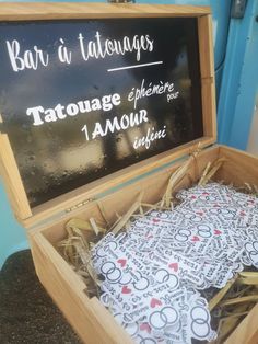 an open wooden box filled with lots of different designs on top of a blackboard