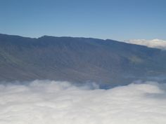 the mountains are covered in thick clouds on a sunny day