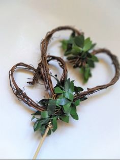 two heart shaped wreaths with greenery on them