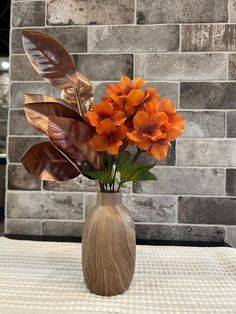 there is a vase with orange flowers in it