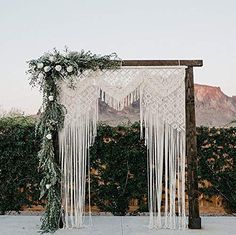 a wedding arch with white flowers and greenery