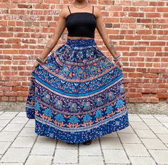 The perfect maxi skirt with pockets  Nice thick material makes it the perfect skirt to twirl in.  Gorgeous blues and oranges with beautiful Indian patterns throughout.  Great for the summer and perfect transition piece for the fall.  Can be worn high waisted or low waisted.  Versatile and fits comfortably with an elastic waist.  Patches include flowers, elephants, mandala prints and more. One size S - L Measurements  Waist 22-44in  Length 37in Lovely cotton material, nice and thick fabric. This Bohemian Wide Leg Maxi Skirt With Pockets, Blue Tiered Maxi Skirt With Pockets, Full-length Summer Festival Skirt, Full Length Summer Festival Skirt, Full Length Skirt For Summer Festival, Bohemian Flared Maxi Skirt With Pockets, Bohemian Maxi Skirt With Pockets, Bohemian Tiered Maxi Skirt With Pockets, Spring Festival Skirt With Pockets