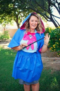 a woman in a blue dress and pink hat is holding a golf club