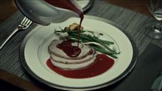 a white plate topped with food on top of a wooden table next to silverware