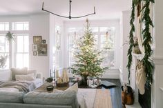 a living room filled with furniture and a christmas tree in the middle of the room