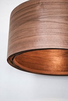 a close up of a wooden light fixture on a white wall with a black background