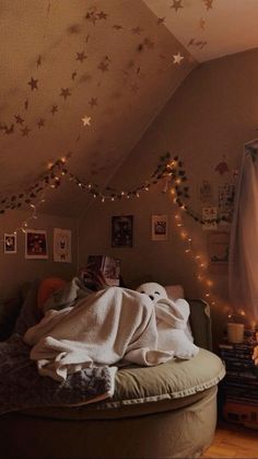 a bedroom with lights strung from the ceiling and stars on the wall above it, along with a round bed