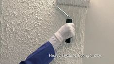 a person in white gloves painting a wall