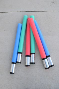 four different colored pens laying on the ground