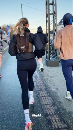 a woman is running down the street in tight pants