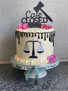 a cake decorated with the scales of justice on top of a table next to a sign that says cafe closed