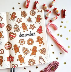 an open christmas planner with ginger cookies and candy canes on the table next to it