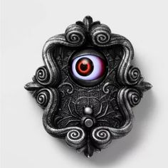 a brooch with an evil eye on it's center and swirls in the middle