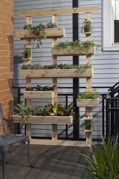 an outdoor planter made out of wooden pallets with plants growing in them on the side of a house