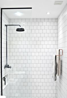 a white tiled bathroom with black accents