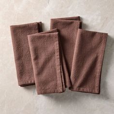 three towels folded on top of each other in front of a marble countertop,