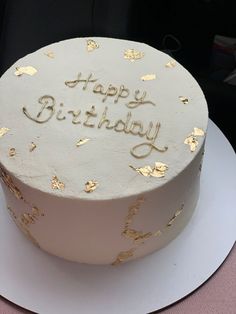 a white and gold birthday cake with the words happy birthday written on it