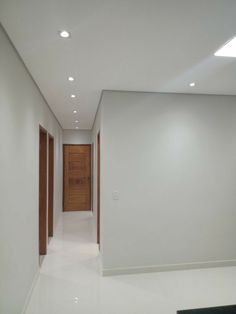 an empty hallway with white walls and wooden doors