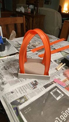 an orange chair sitting on top of a newspaper