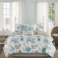 a bed with blue and white comforters in a room