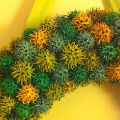 an arrangement of green and yellow flowers on a table