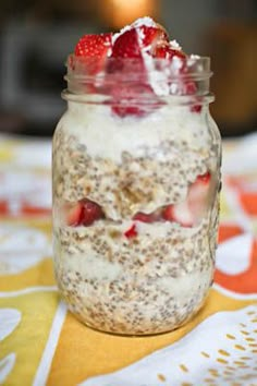 a jar filled with oatmeal and strawberries on top of a table